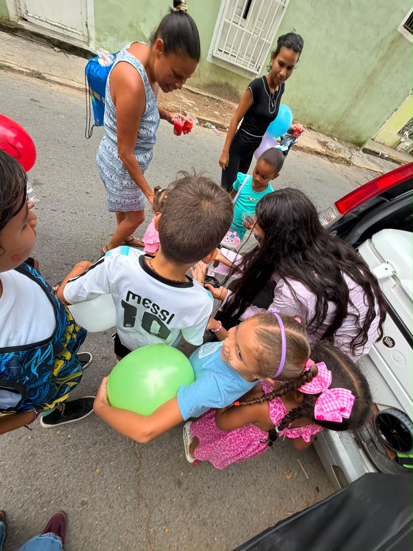 Entrega de galletas y globos junto al carro